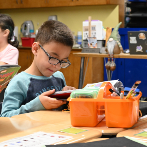 A student reads to himself during class