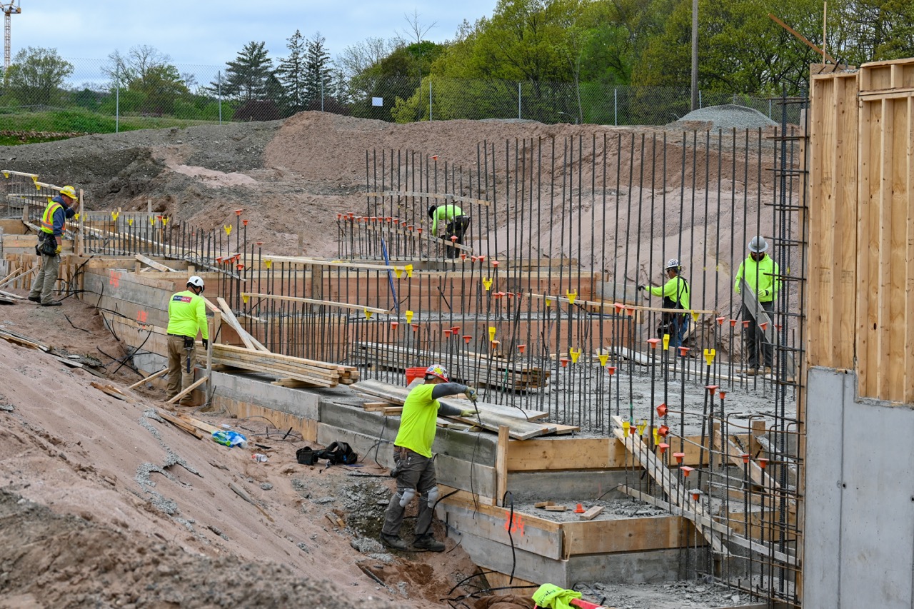 Construction workers secure building foundation