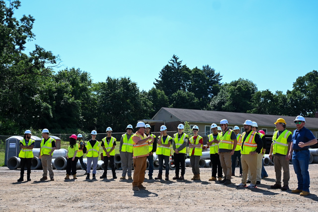 Group of Dean students listen to leaders speak about the site