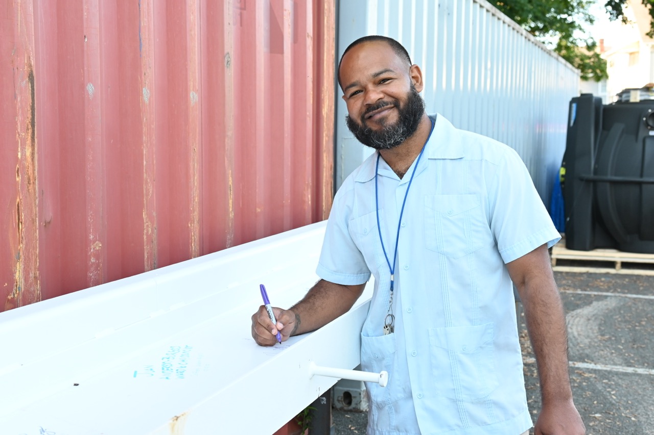 A city counselor signs the beam