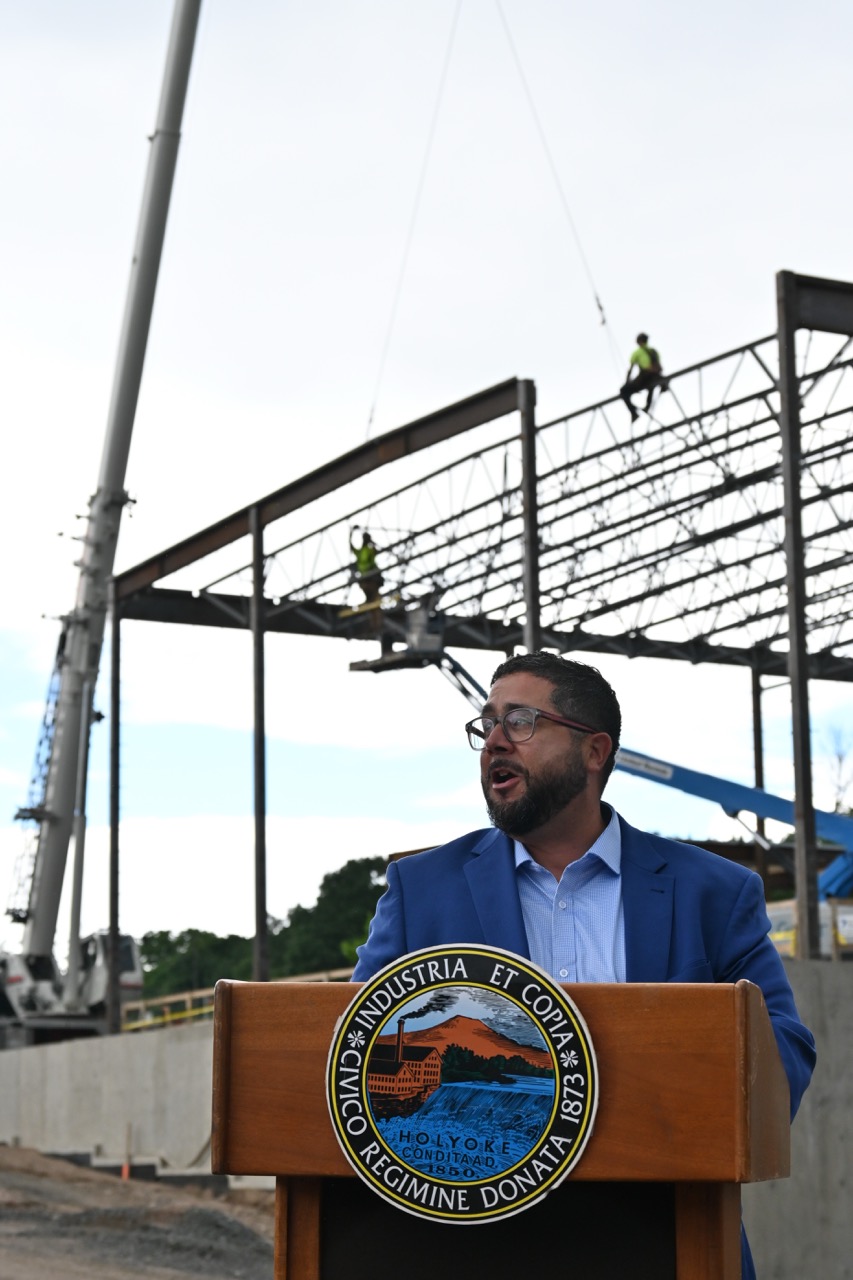 Superintendent Soto speaks with works securing the frame in the background