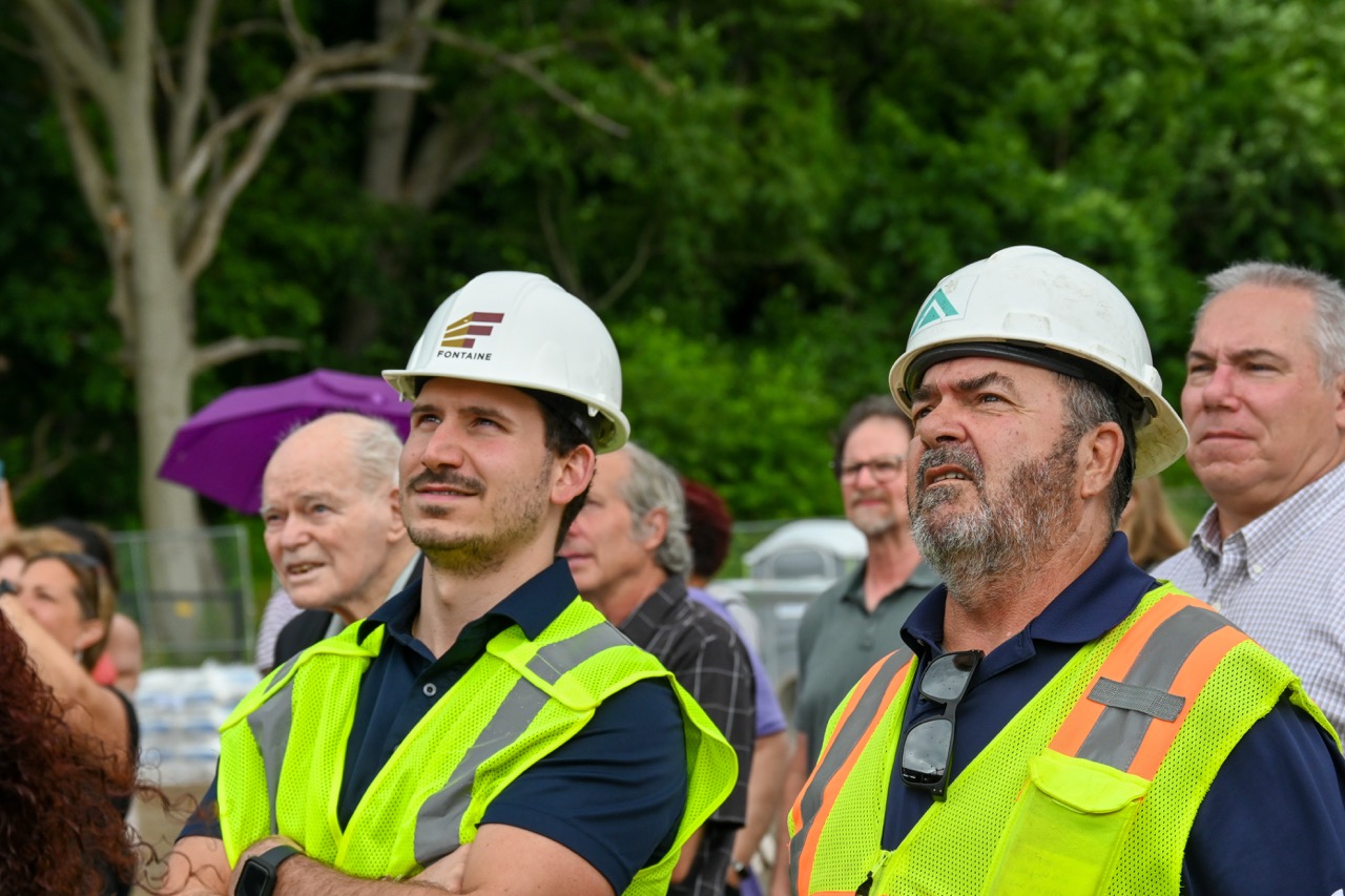 Two project leaders look up at the beam