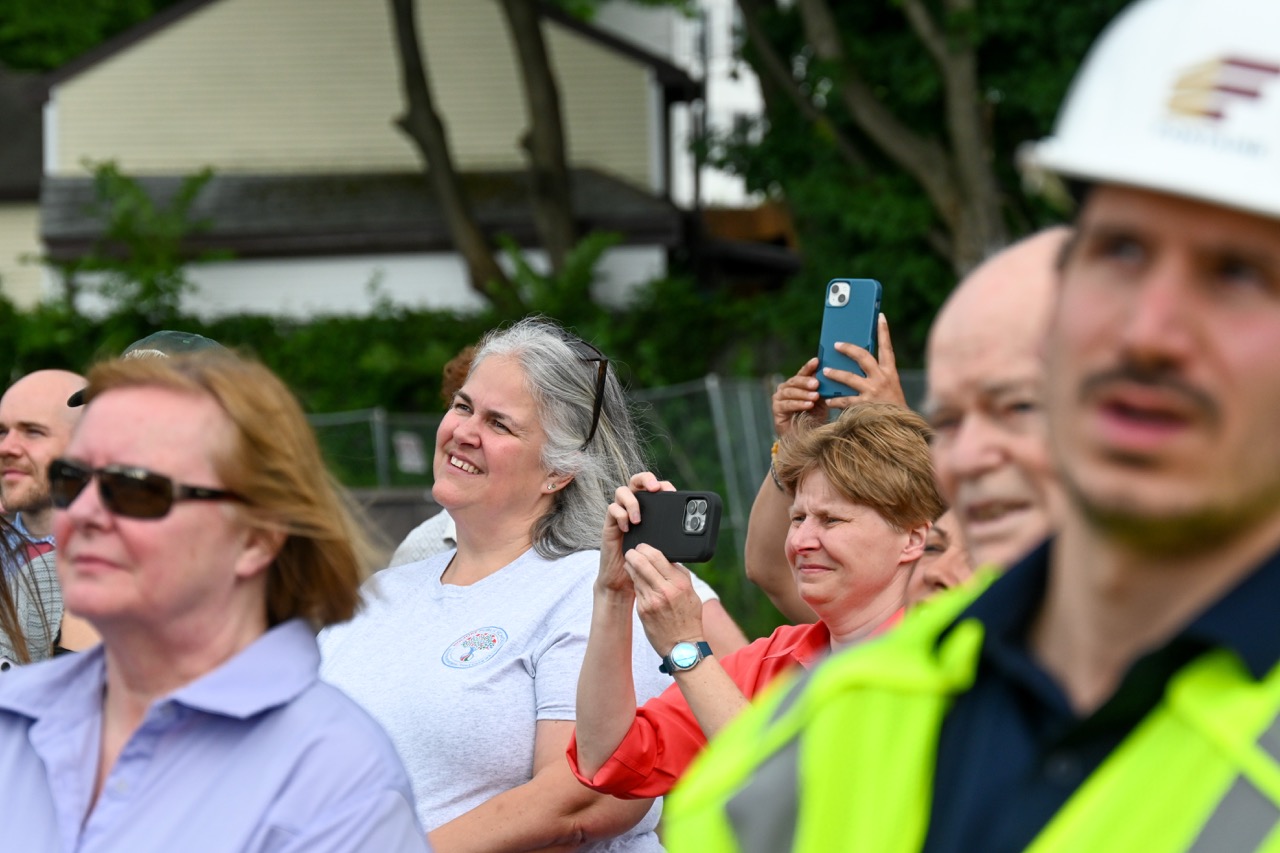 Marianne Currier smiles at the beam being placed