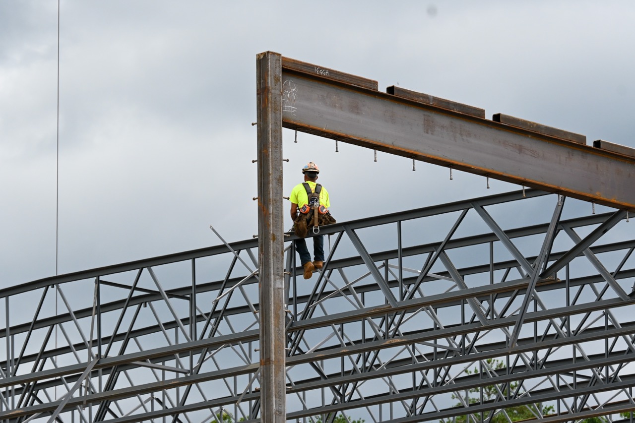 A construction worker waits to secure the beam