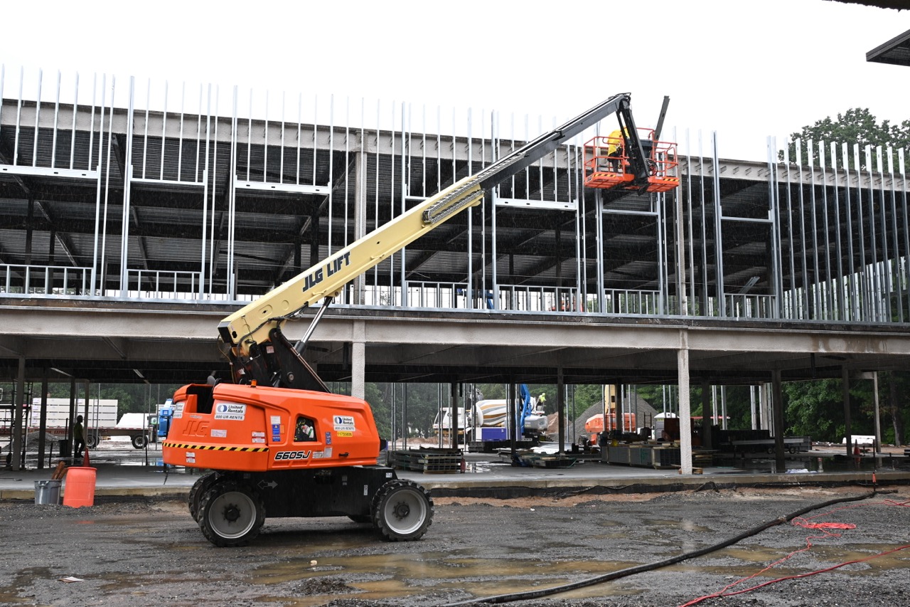 A machine lifts workers up to the window frames