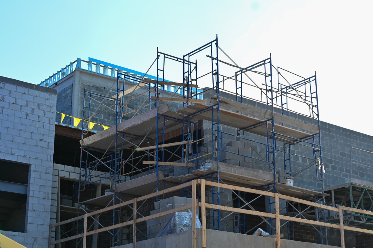 An outside look at scaffolding near a nearly-finished wall