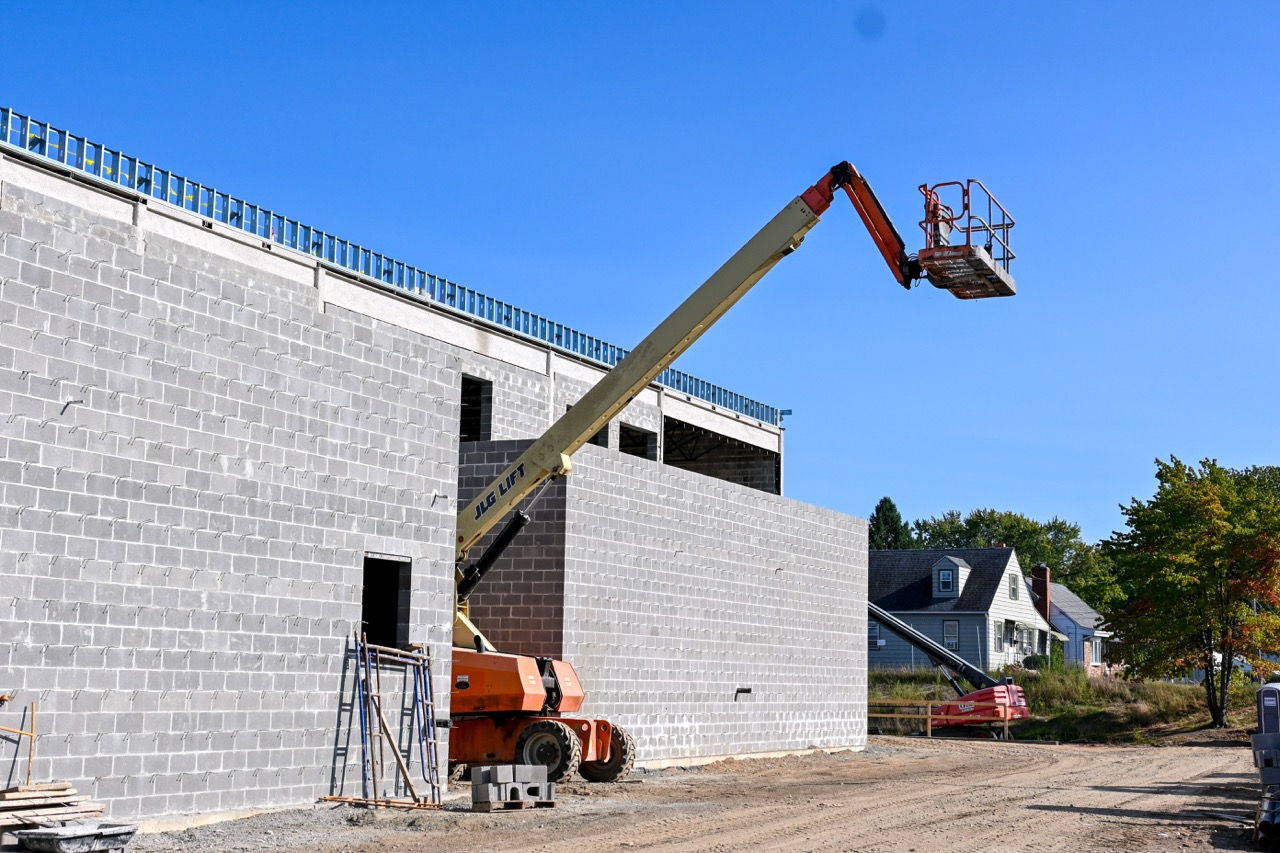 A cherry picker gives a worker a high view of the outer cafeteria wall