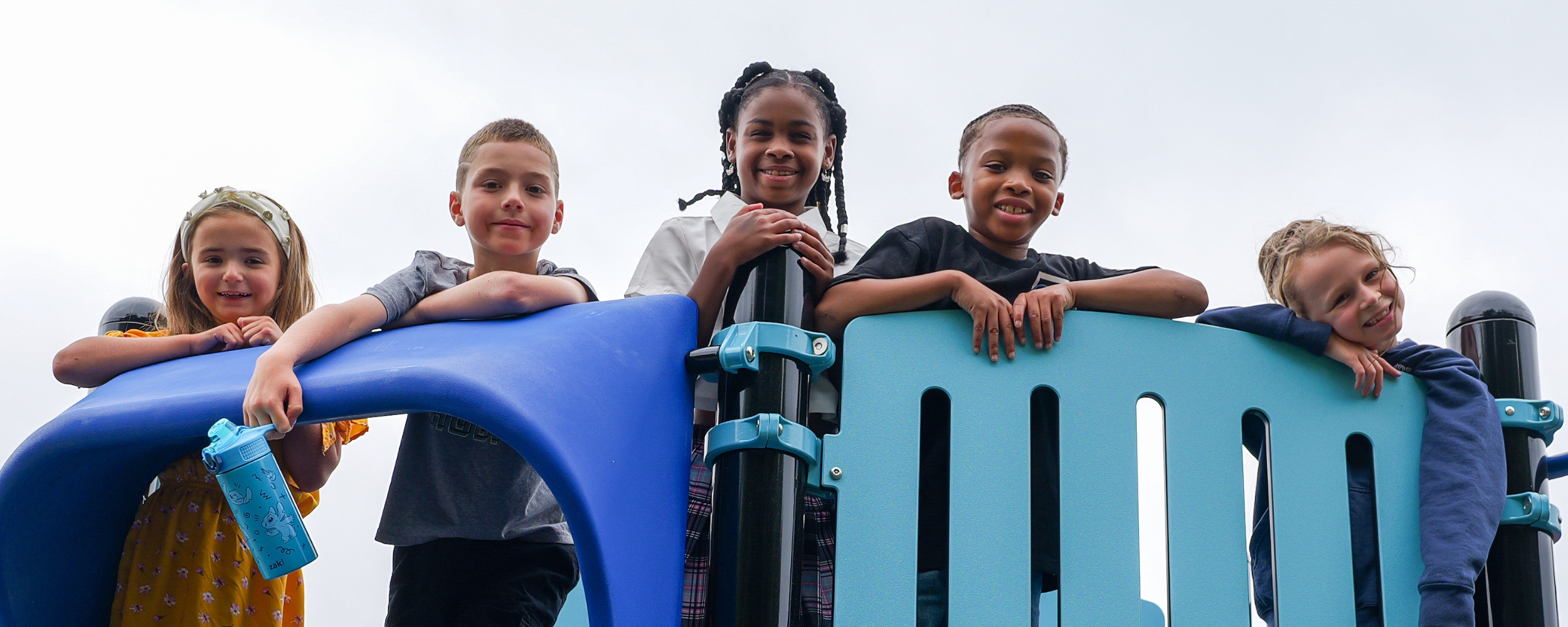 Students smile on the new playground at McMahon school