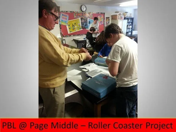 Teacher helping kid on project in classroom