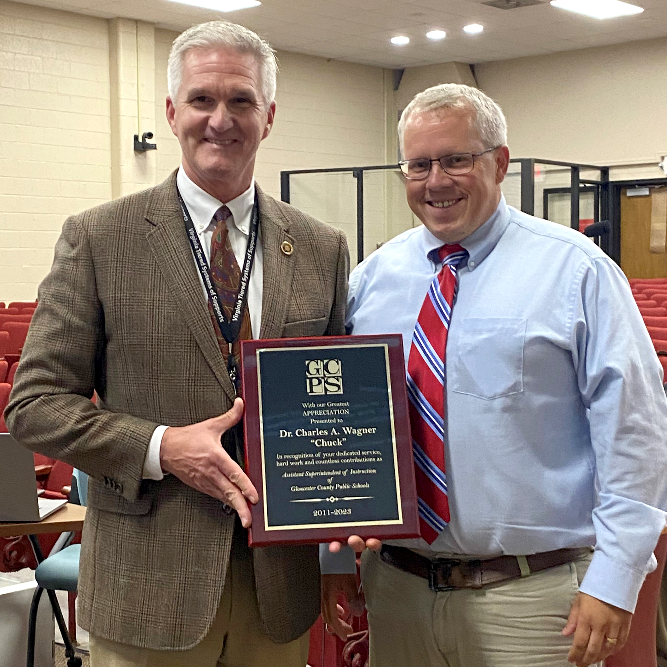 Dr. Wagner is presented with a plaque by Troy Andersen in appreciation and recognition for all his work as assistant superintendent. 