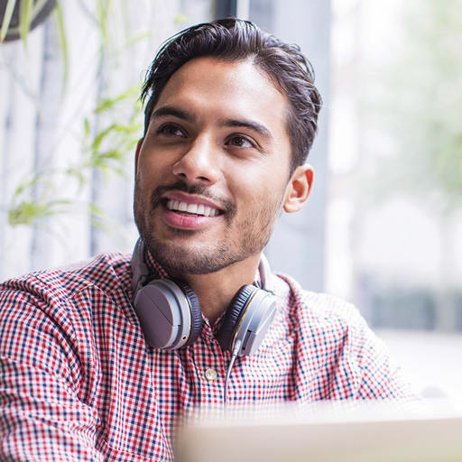Man smiling wearing headphones around his neck