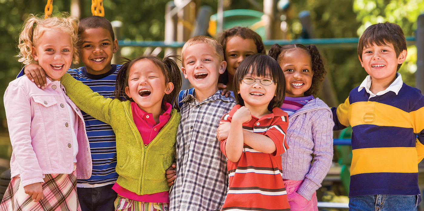 Multi-racial students with arms around each other at a playground