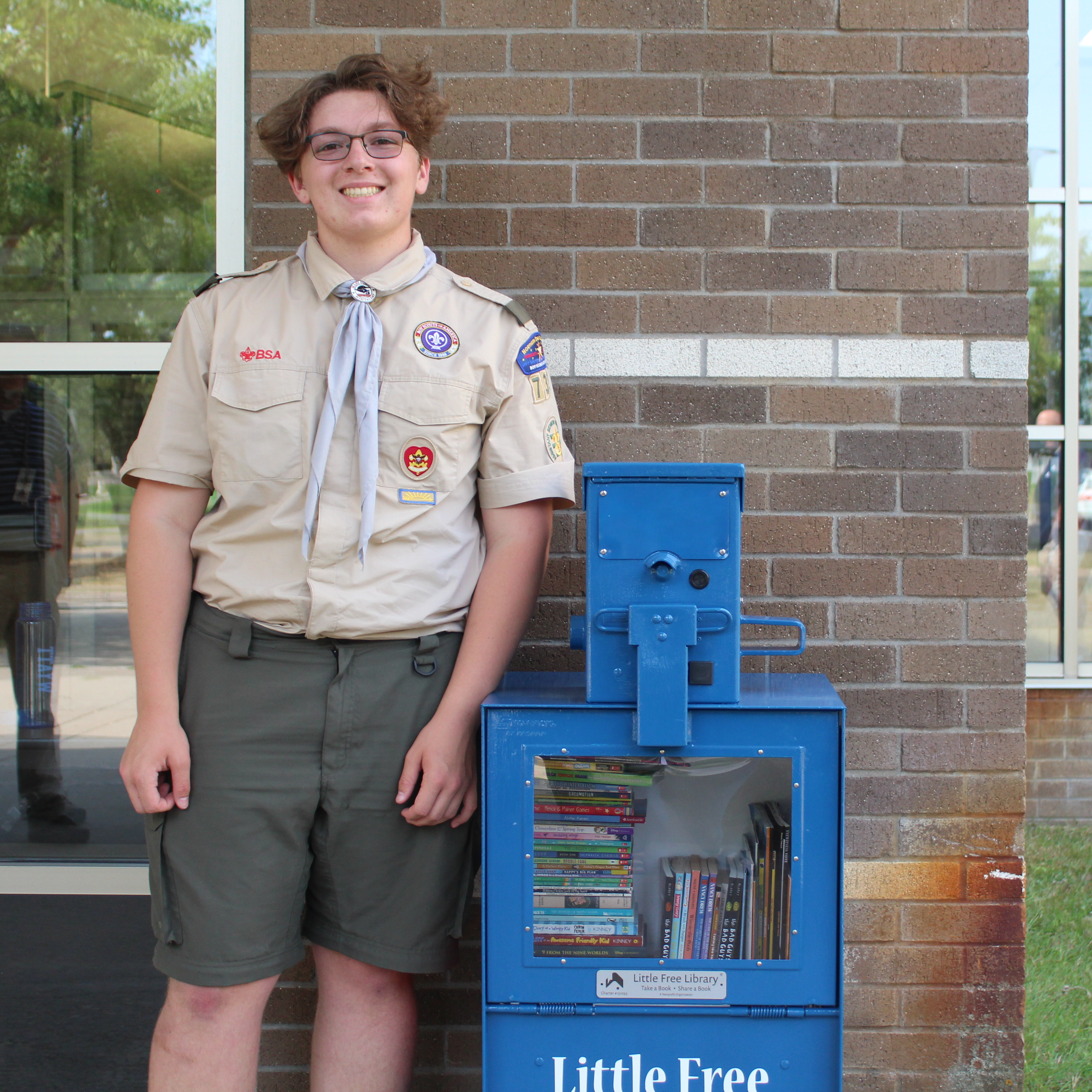 Image: Michael standing with his little free library