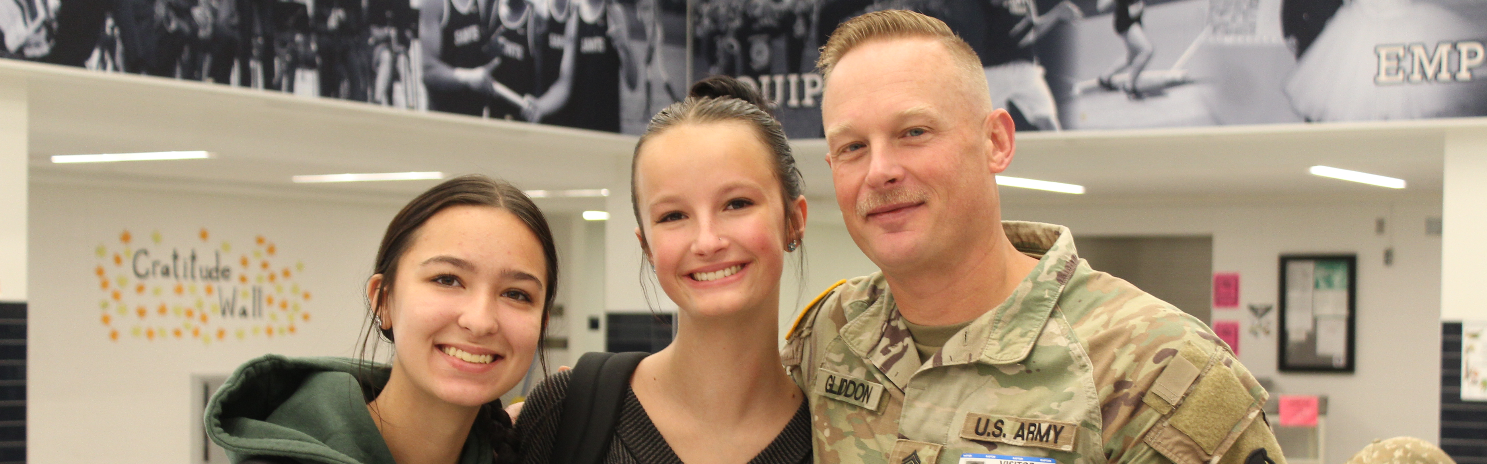 man in military uniform with high school students