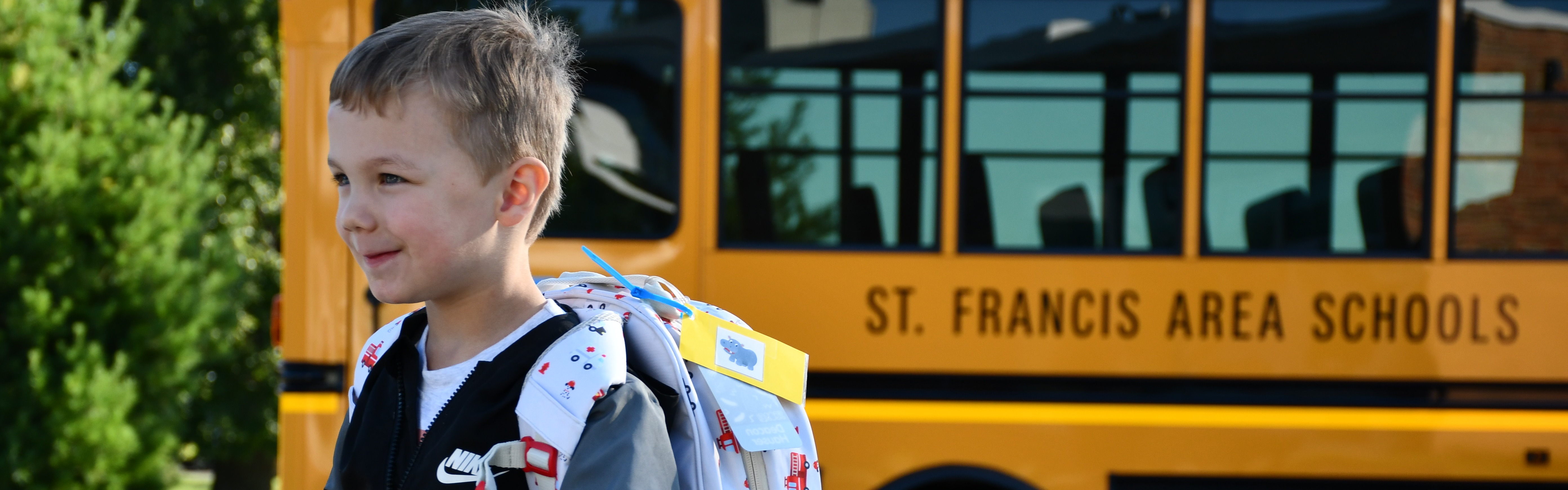 student walking with bus in the background