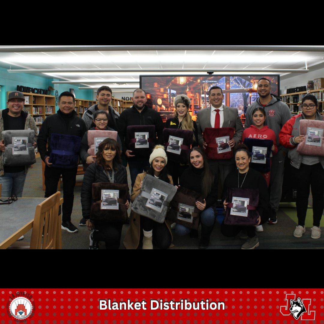 staff and students posing with community members after blanket distribution