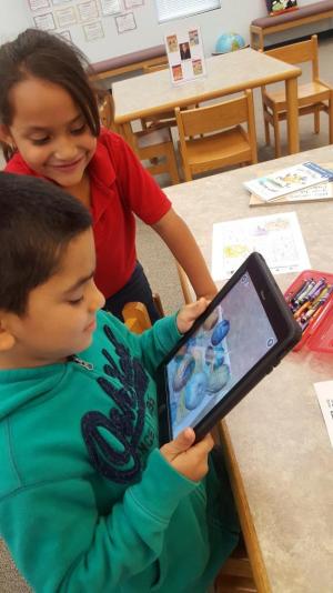 kids at the library playing and using different apps on a tablet