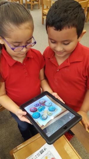 kids at the library playing and using different apps on a tablet