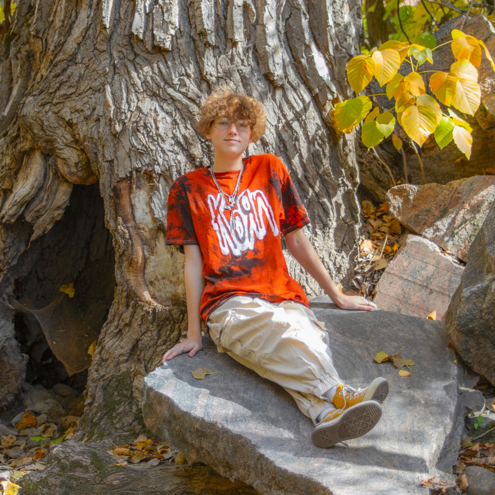 teenager leaning against tree