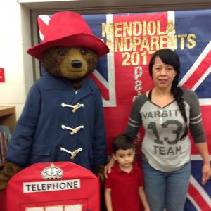 A student and parent posing with a life size Paddington the bear