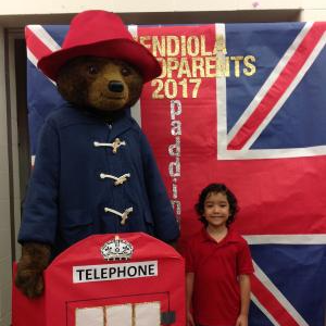 A student posing with a life size Paddington the bear