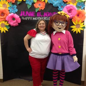 A staff member posing with a Junie B. Jones character