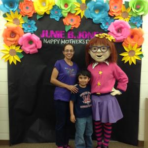 A parent and student posing with a Junie B. Jones character