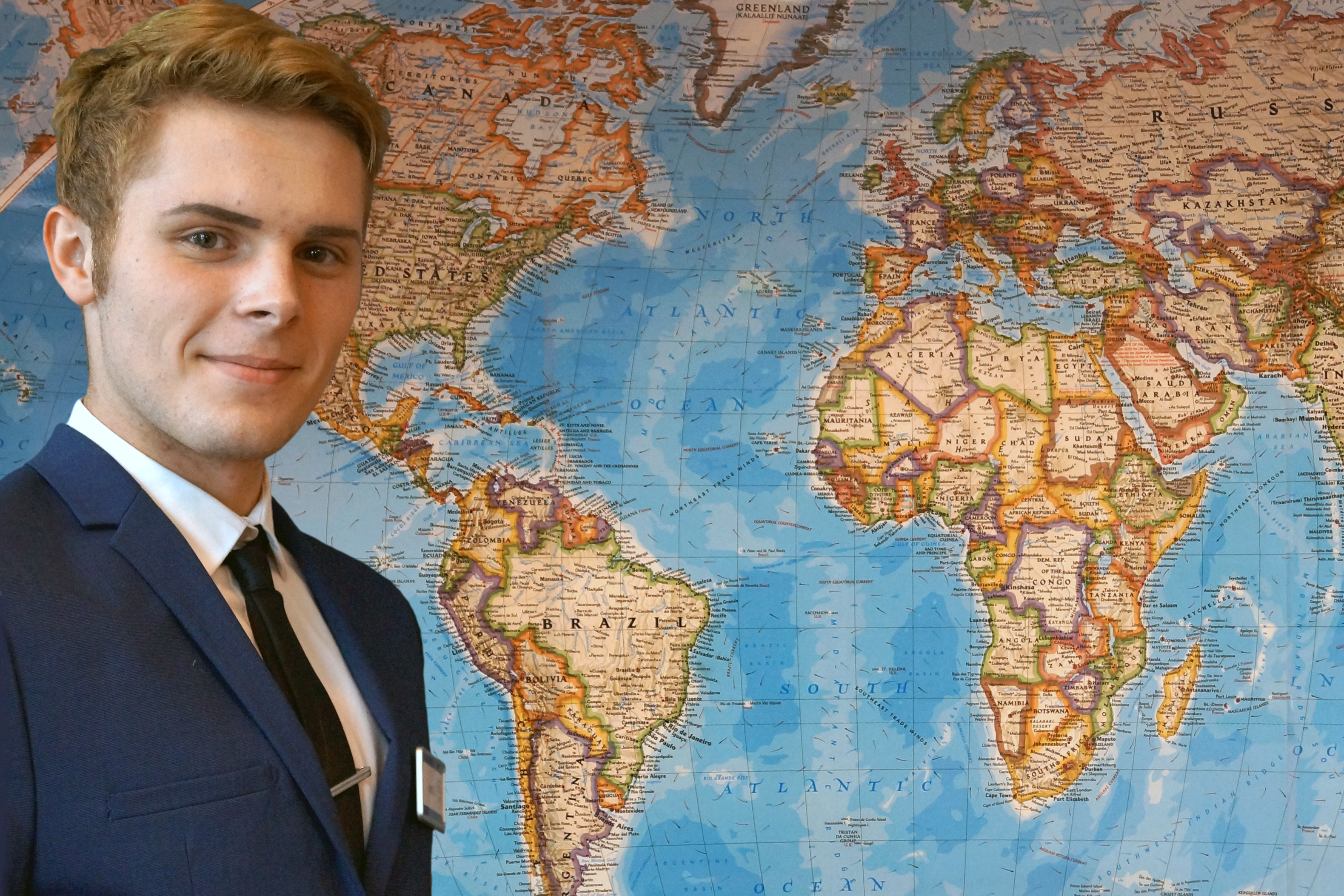 STUDENT IN UNIFORM IN FRONT OF WORLD MAP