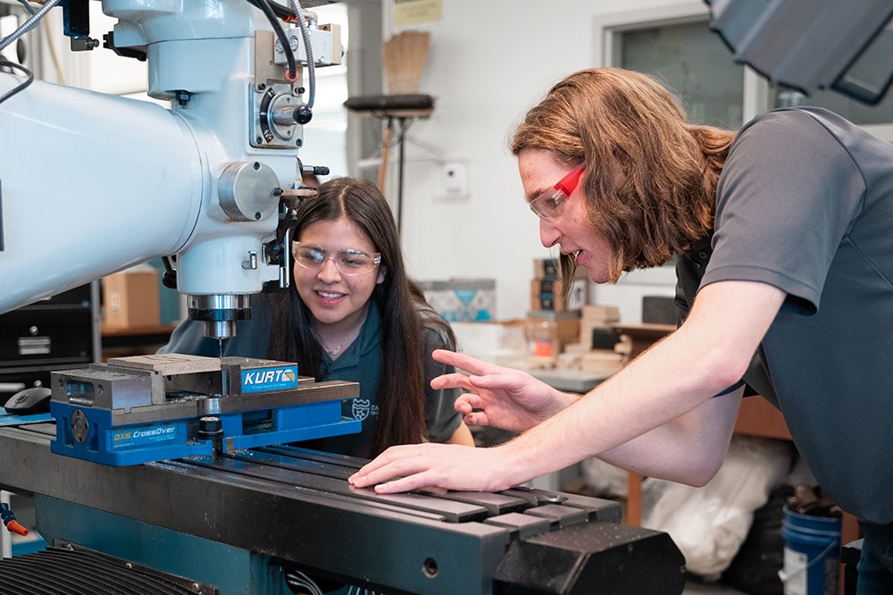 STUDENT WORKING ON A LASER CUTTER