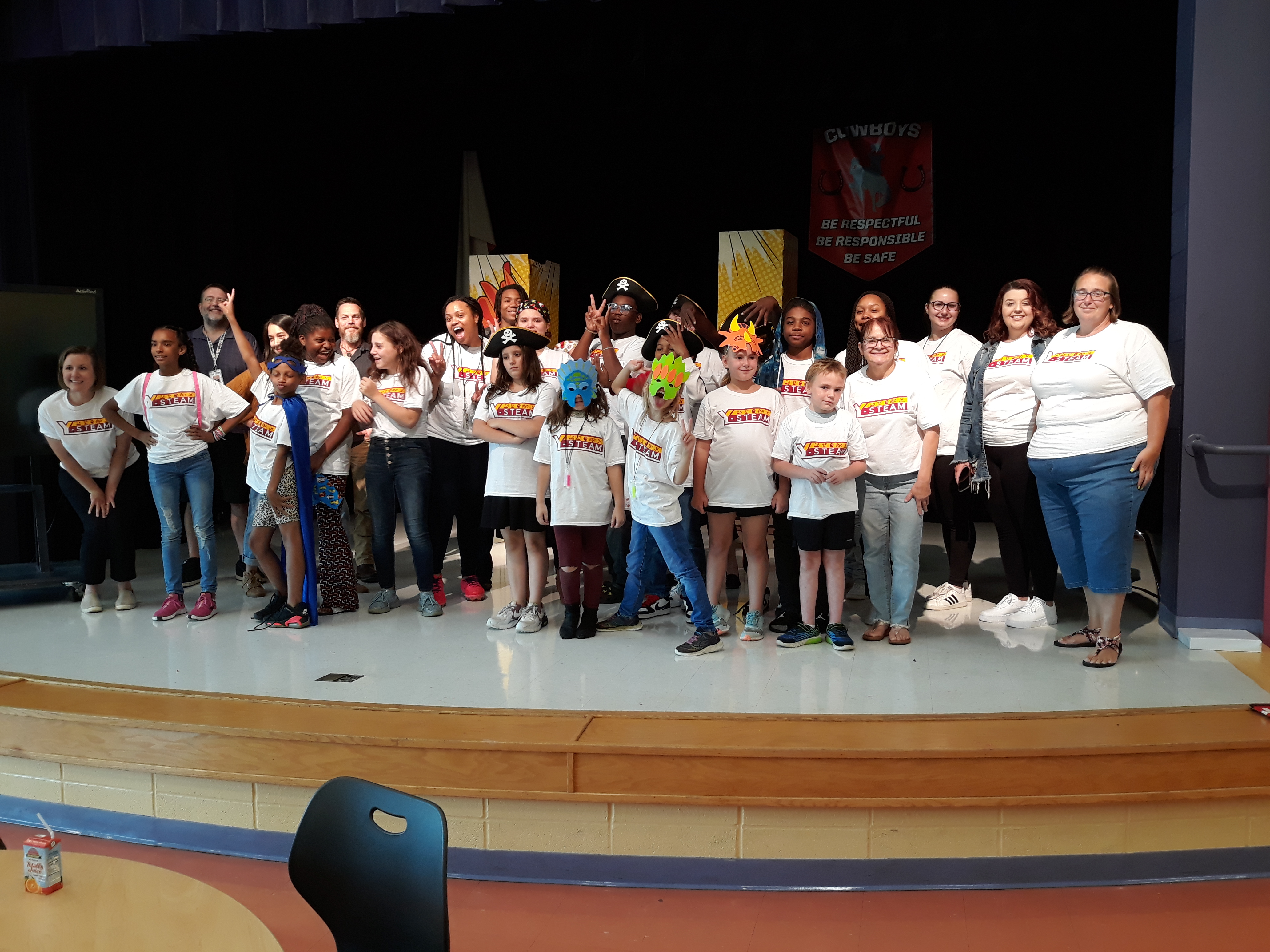Photograph of Y-STEAM scholars on a stage wearing Y-STEAM t-shirts