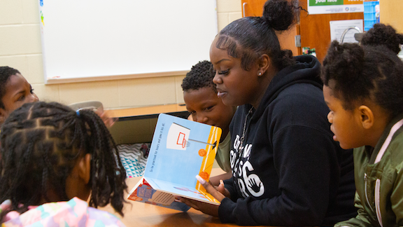 Female teacher reading to elementary students