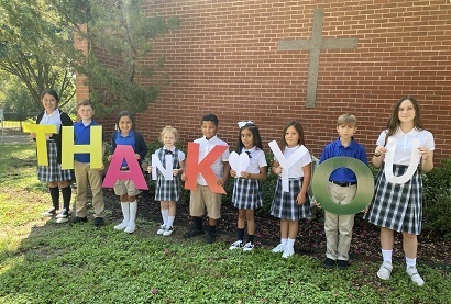 students holding letters spelling out Thank you 