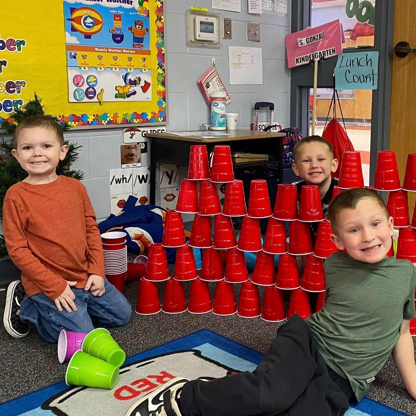 Young boys stack cups into a pyramid