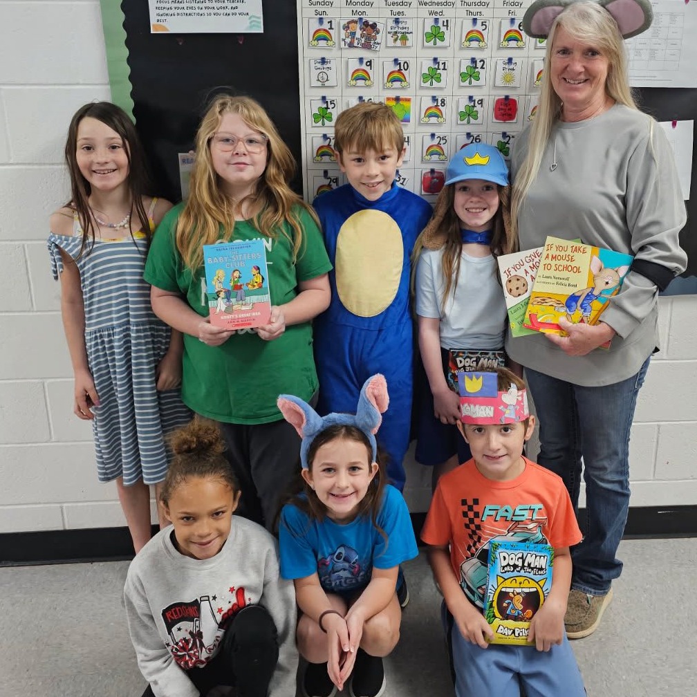 students and teachers pose with favorite books