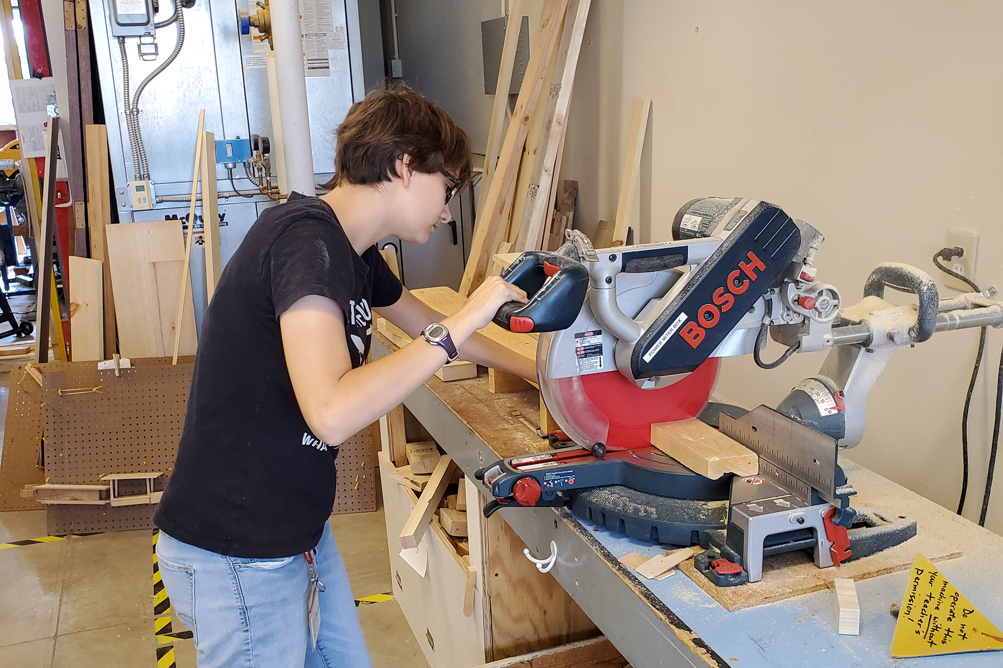 High School student using table saw in wood shop