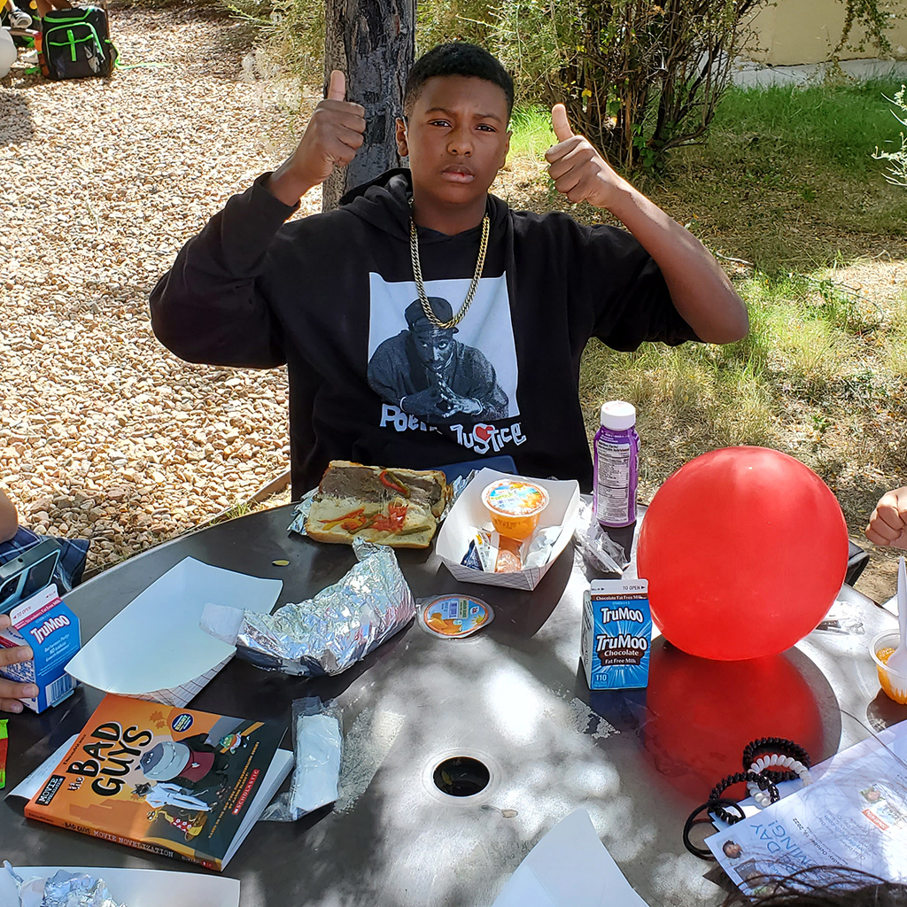 Student giving thumbs up during outside lunch 