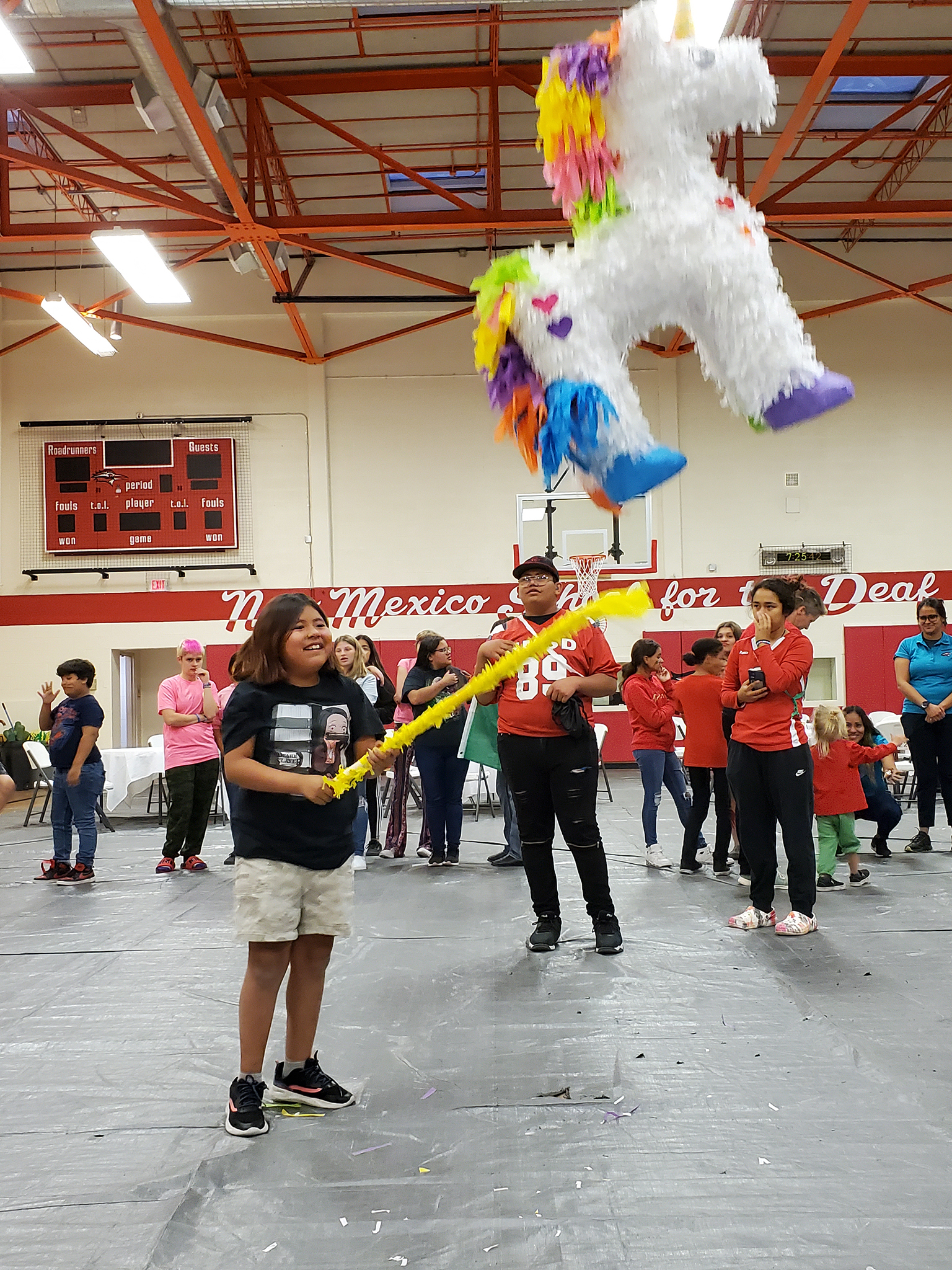 Child hitting a piñata at event in the Larson Gym