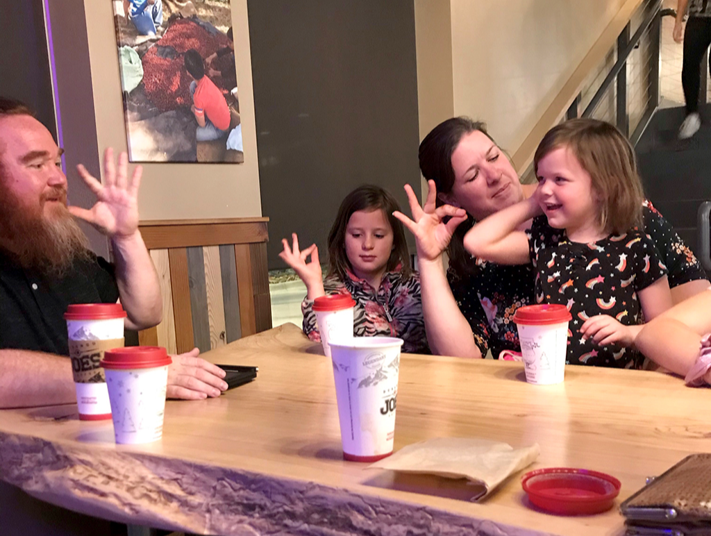ASL Tutor teaching a family the sign "cat"
