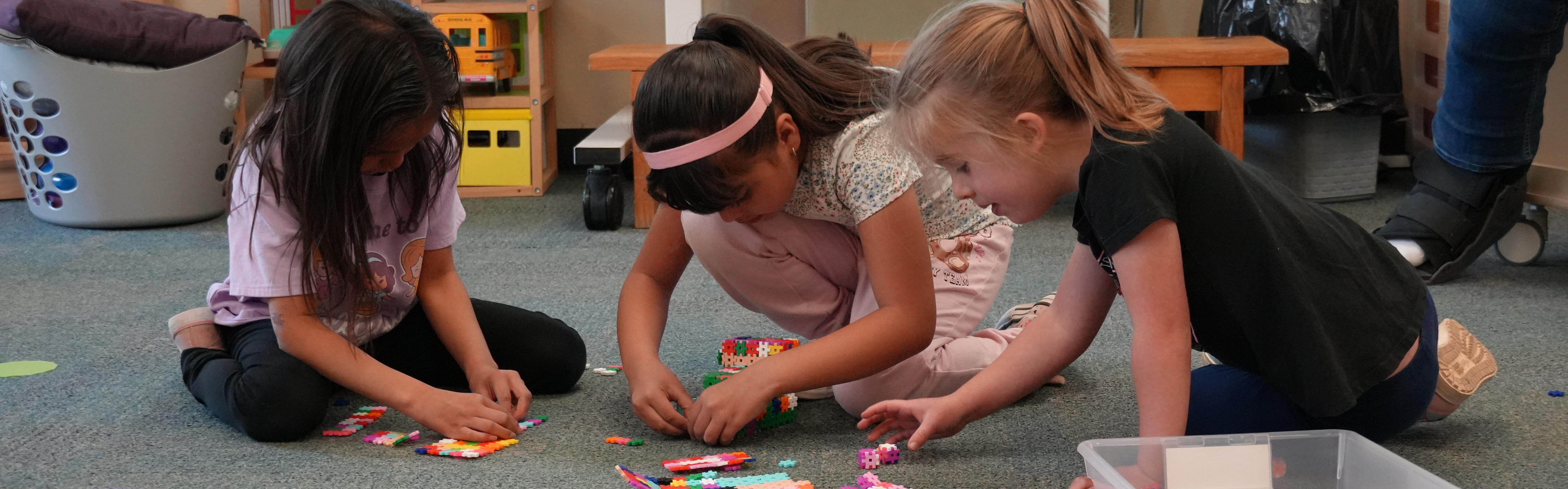 3 girls playing with puzzle pieces
