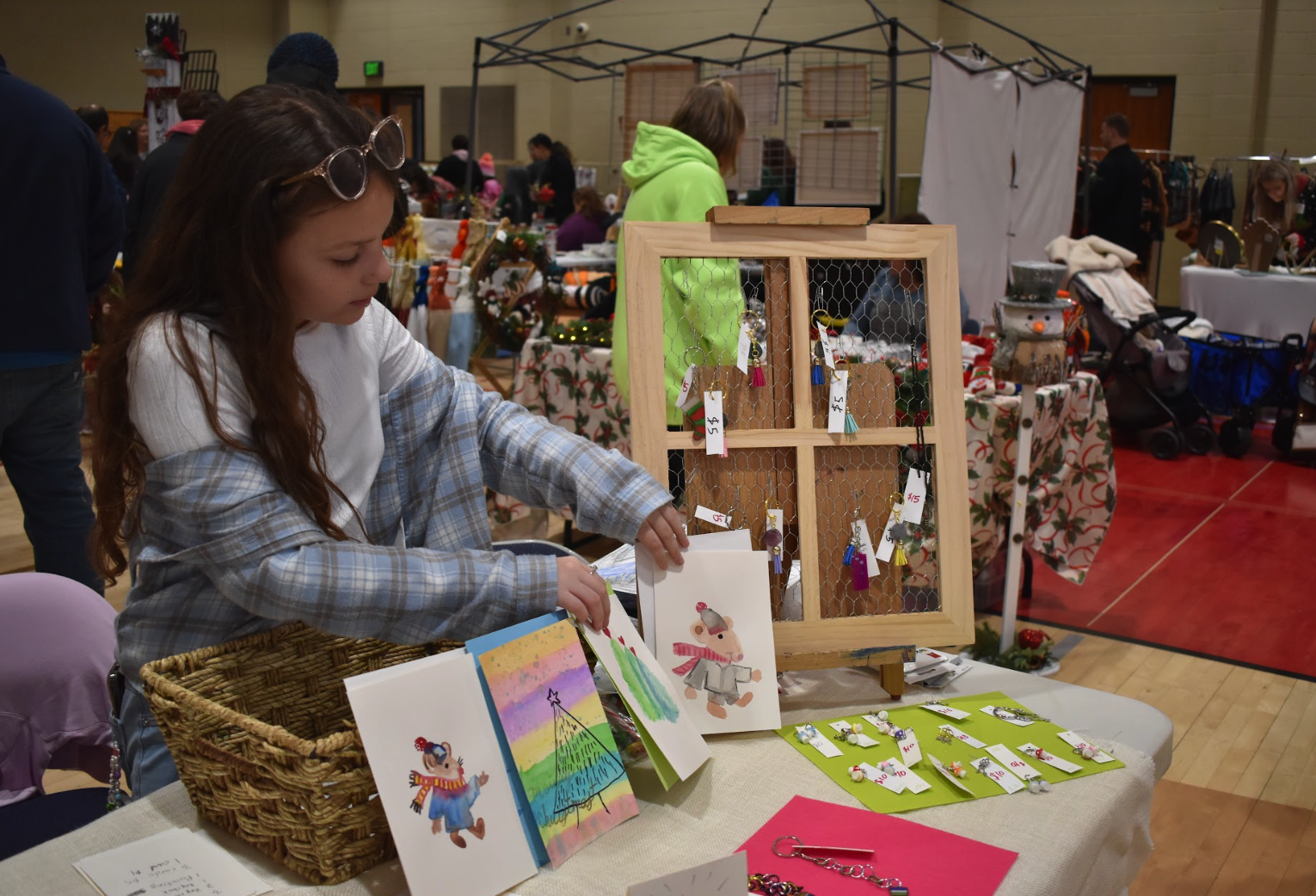 ICS student setting up artwork for sale at the Holiday Craft Fair.