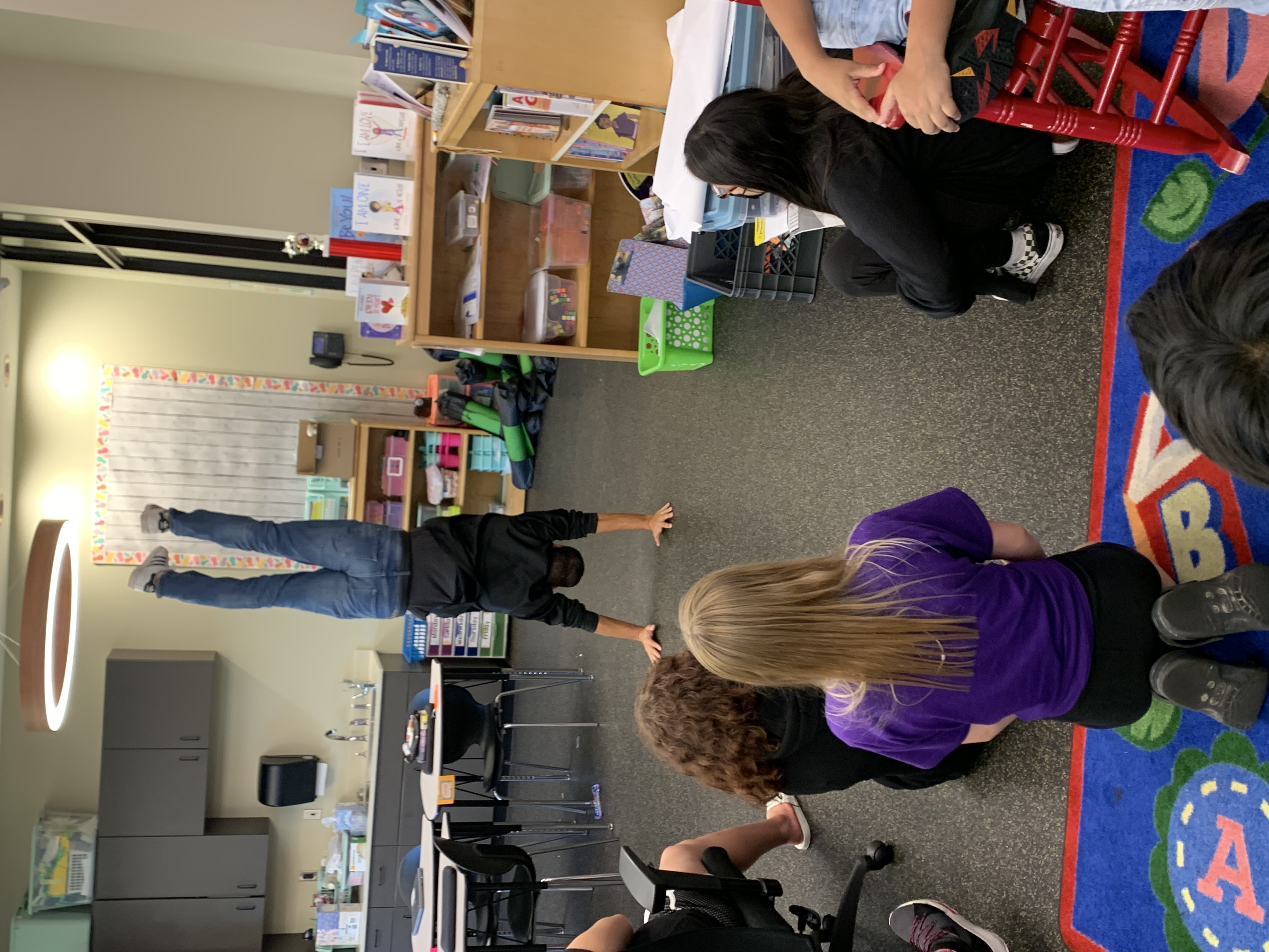Mr Dropik doing a handstand in front of students who are sitting watching him in their classroom.