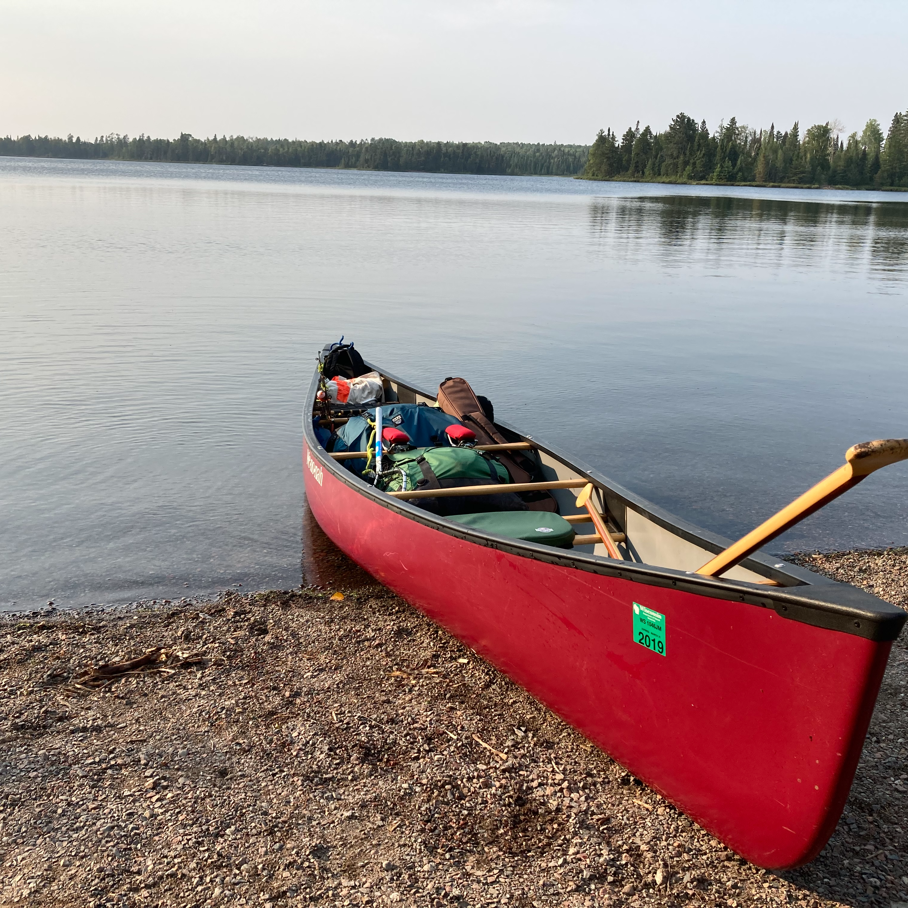 red canoe on a lakeshore