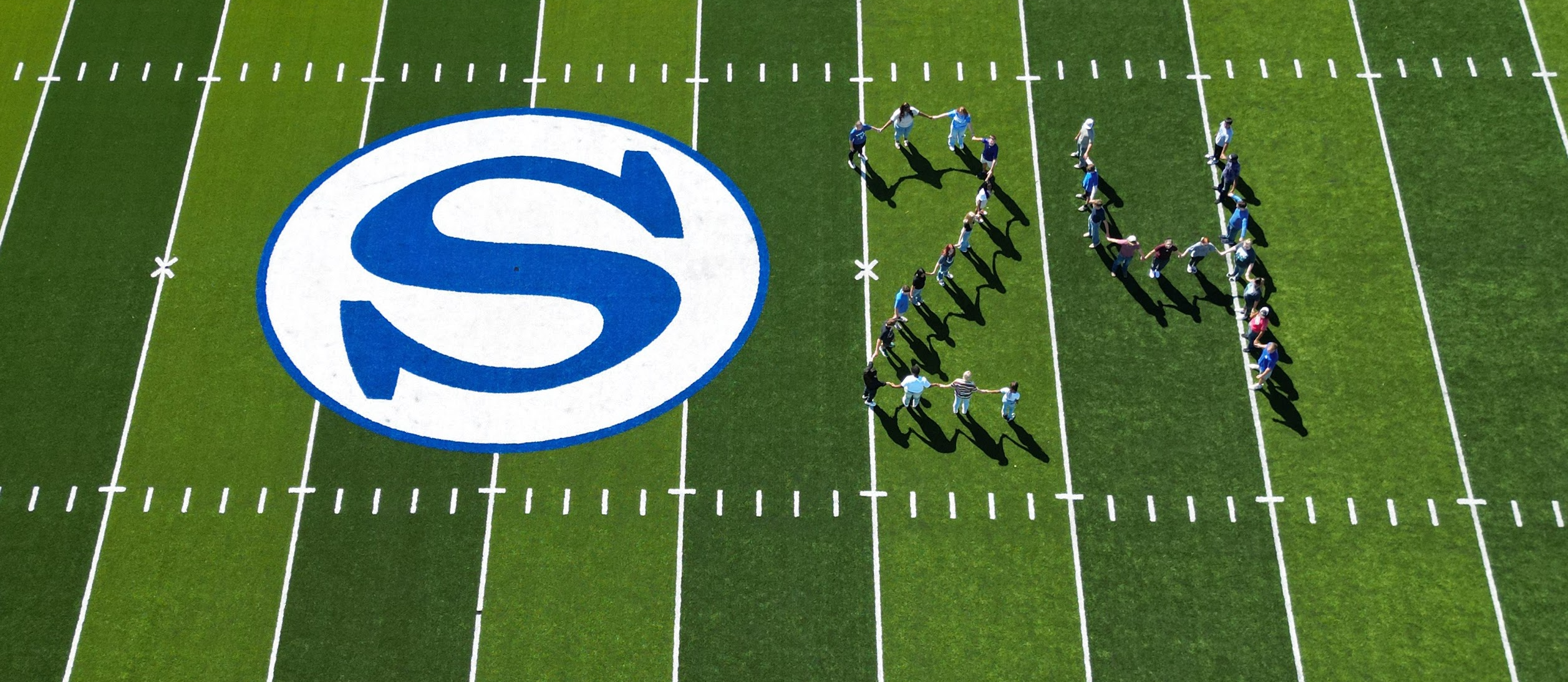 Aerial drone picture of the Class of 2024 spelling out 24 on football field