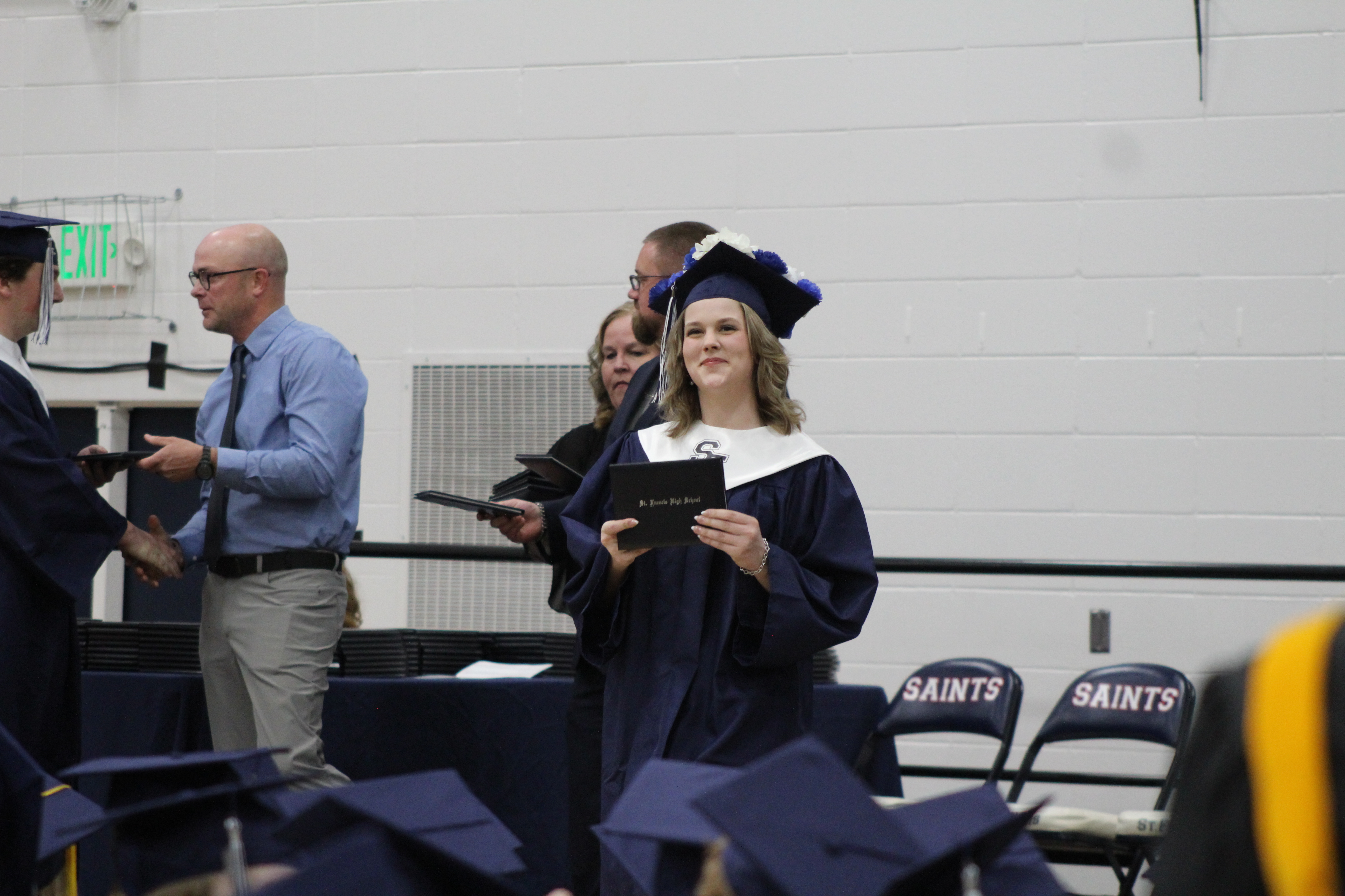 Graduate proudly displaying diploma folder