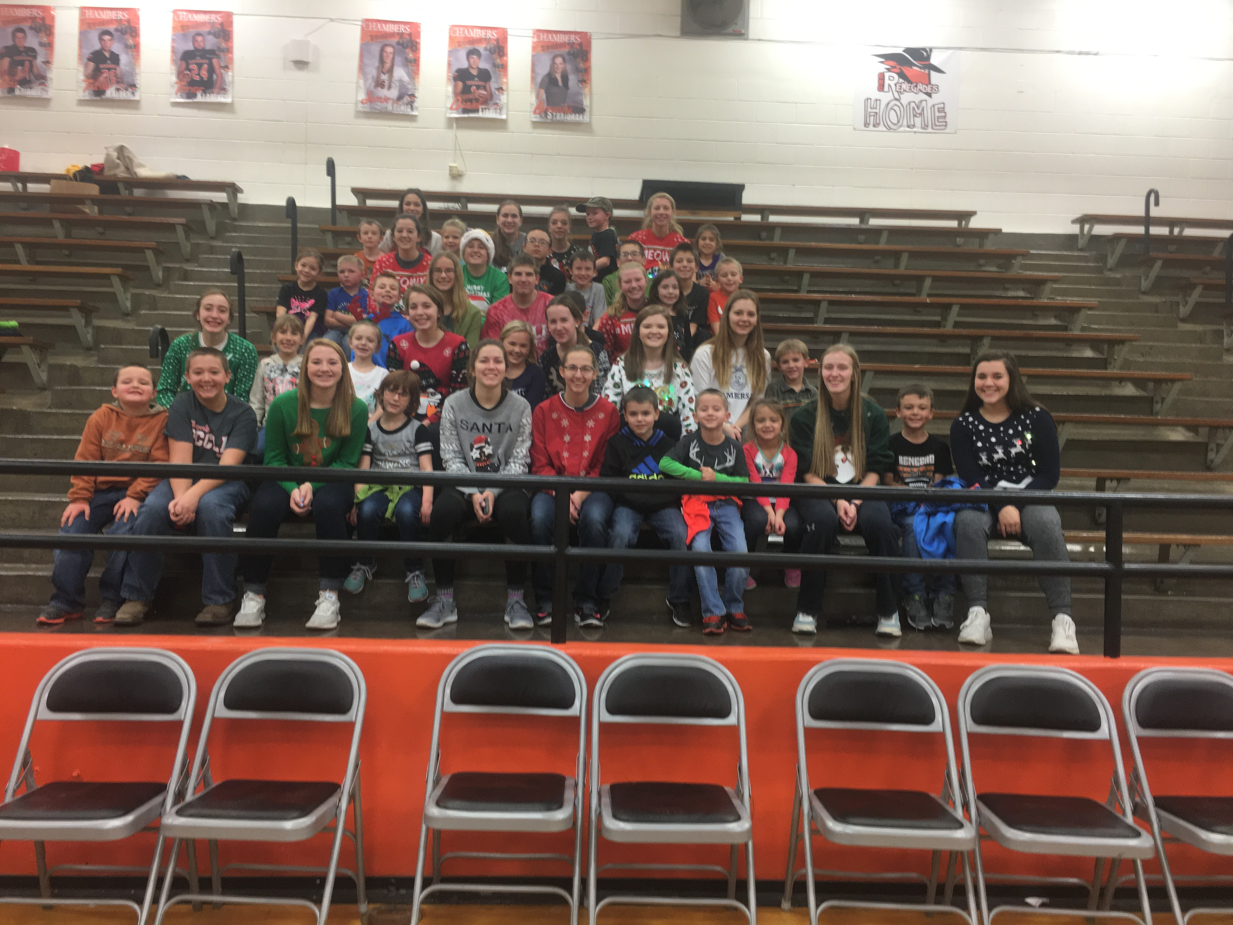 A photo of students at the Coyote Chum Party in the gym sitting on the bleachers