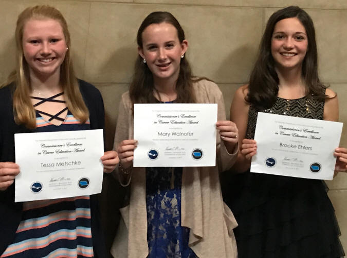 A photo of three freshman girls with their awards received from the governor for receiving top honors at the National FFCLA convention