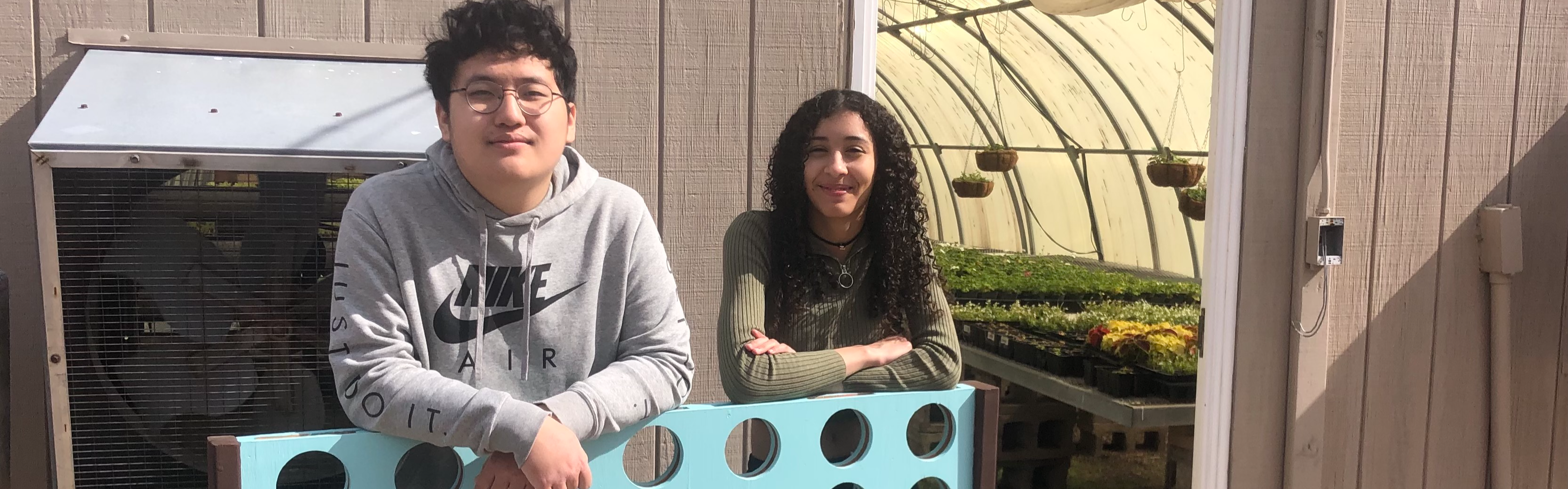 Image: Two Students standing outside of the green house