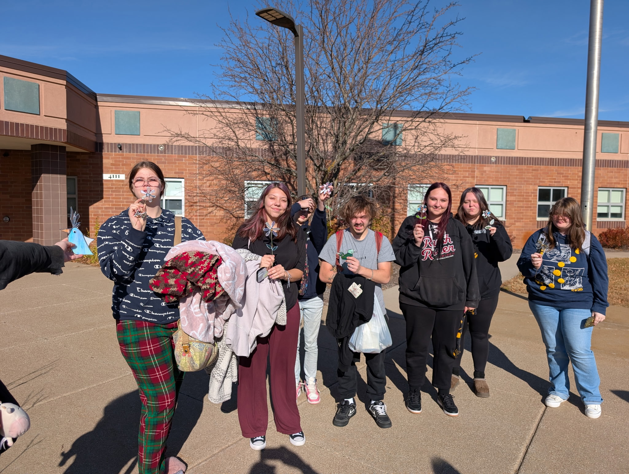 students in front of the building displaying artwork