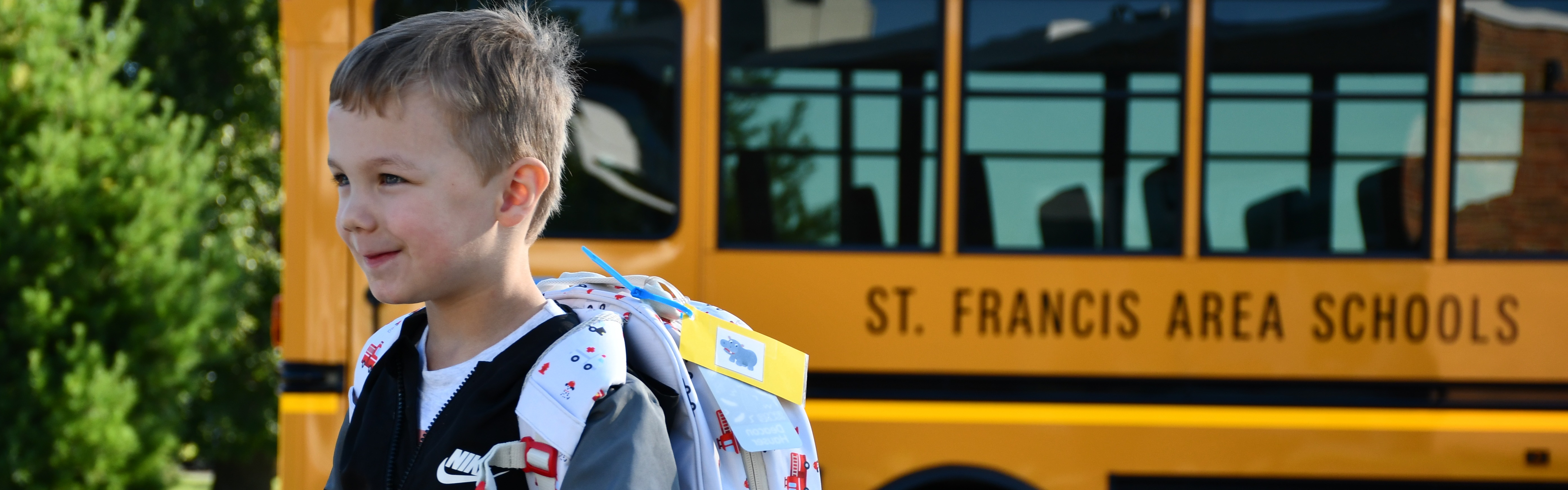 student walking with bus in the background