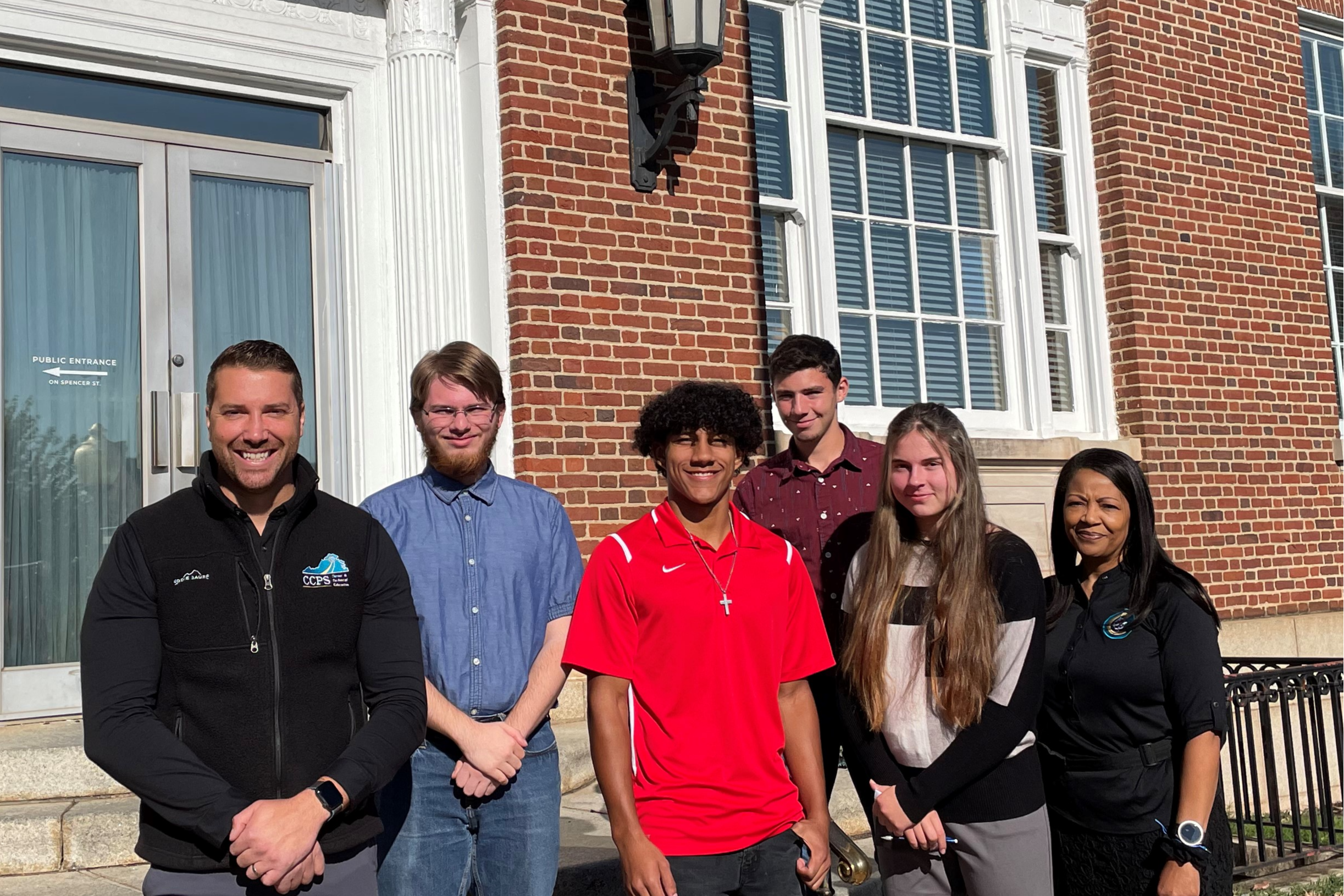 students in front of brick building